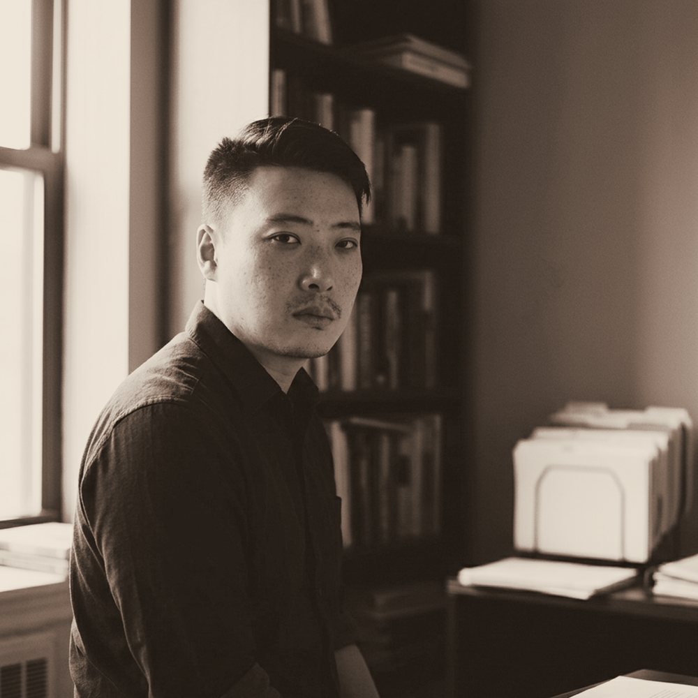 Fury Song standing at a desk of annotated documents.